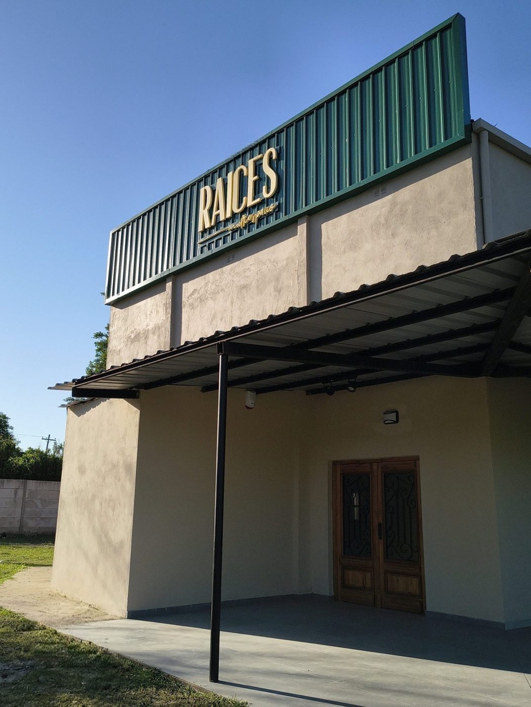 Fachada de Raíces Multiespacio con su cartel