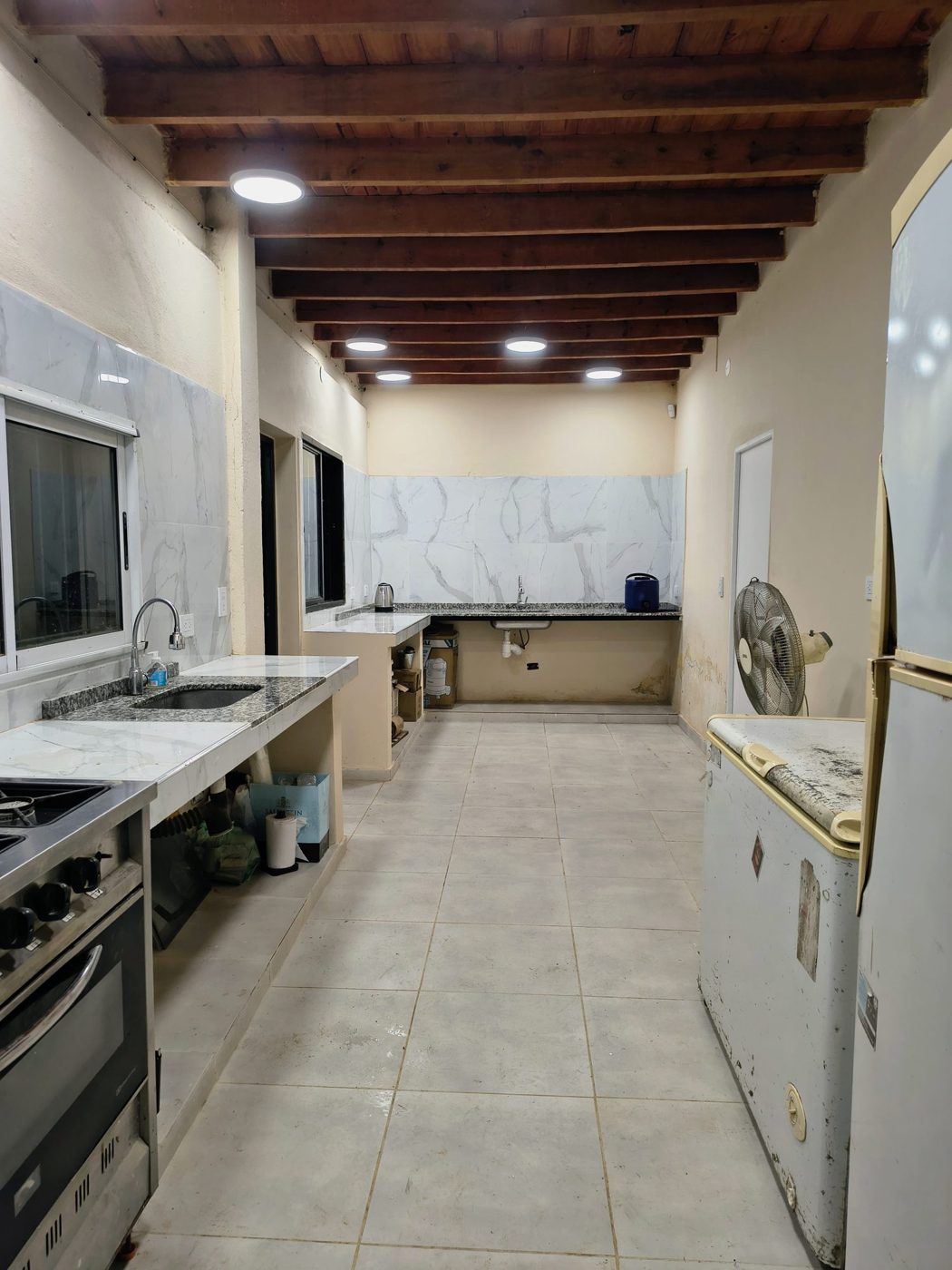 Cocina equipada con mesadas, cocina industrial, heladera y freezer